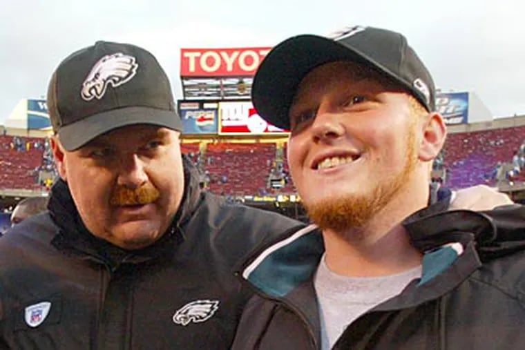 Andy Reid walks off the field with his son, Britt, after the Eagles beat the Giants in 2004. (Yong Kim / Staff file photo)