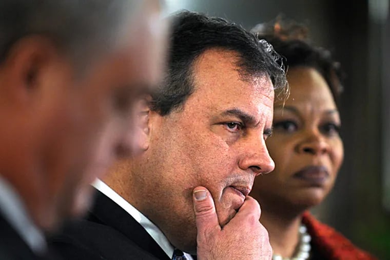 Gov. Christie listens to other officials after announcing that the state of New Jersey is taking over the school system in the city of Camden. With him is Camden Mayor Dana L. Redd at Woodrow Wilson High School. TOM GRALISH / Staff Photographer