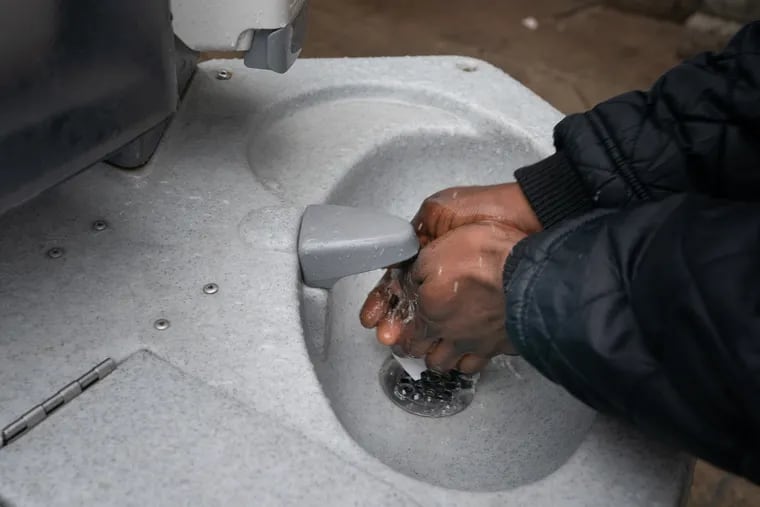 A man uses an outdoor hand washing station at Broad Street Ministry, which is sponsoring a hygiene truck that will include personal-care items such as toothbrushes and soap, as well as portable sinks for people experiencing homelessness.