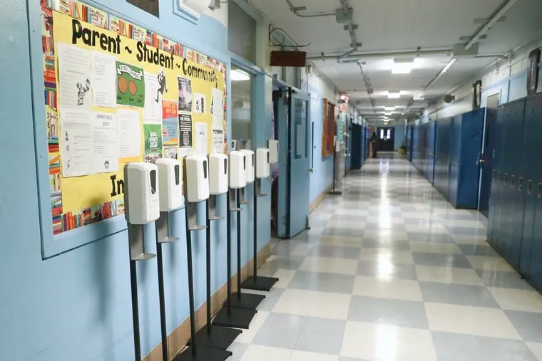 Hand sanitizers line the hallway in this file photo of Paul Robeson High School in University City in Philadelphia. Federal aid has helped Pennsylvania's public schools afford new technology to provide remote instruction during the pandemic, but the state will have to step up when the money runs out, a new report warns.