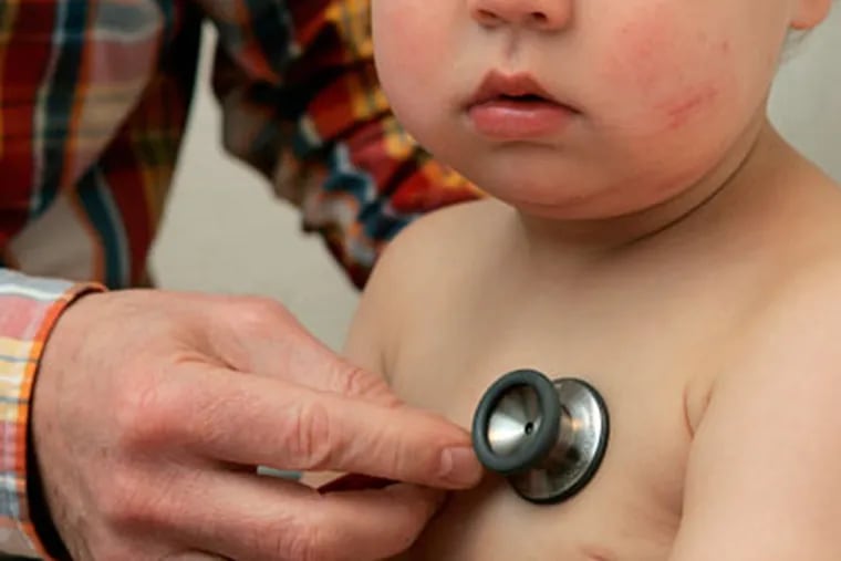 A pediatrician examines a baby. (AP Photo/ Joerg Sarbach)