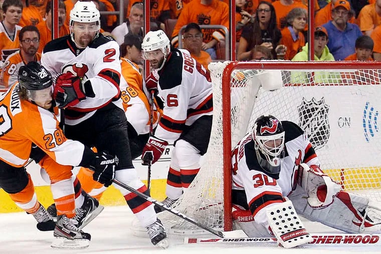 Claude Giroux , here getting taken down in Game 3 by the Devils' Marek Zildlicky as goalie Martin Brodeur stops the puck, is among the Flyers stars who have struggled in this series. YONG KIM / Staff Photographer