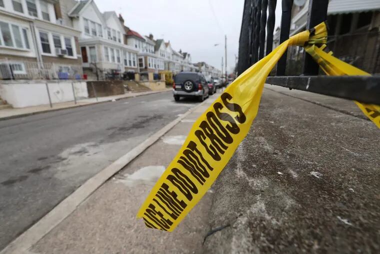 Philadelphia police crime tape remains tied to a porch rail along the 6600 block of Dorel Street in Southwest Philadelphia on Friday morning December 22, 2017. Four people were shot, one died late Thursday evening.