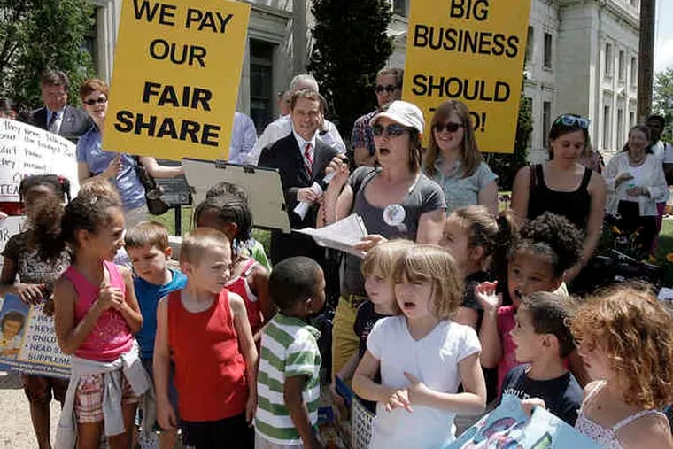 Among state-budget demonstrators in Media is Gretchen Elise Walker (center), singing with children from the Step by Step Learning Center in Delaware County. The message: Raise business taxes, and don't cut funds to education and social services.