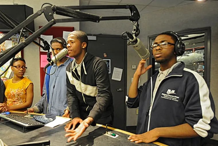 Marques Carson (center), 17, a senior at Mastery Charter School, Thomas Campus (right), talk live on Power 99's the Hot Boyz show (hosted by Uncle O and Mikey Dredd) about flash mobs as fellow teens Martisha Hardy, 17, a senior at Academy at Palumbo, John Laderer, 16, a junior at Overbrook High, and Nicholas Richardson, 17, a senior at Mastery Charter School, listen. (Clem Murray / Staff Photographer)