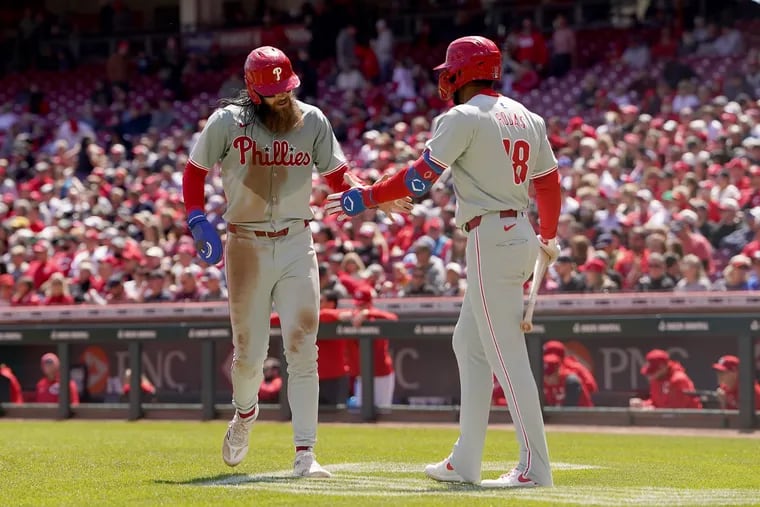 Brandon Marsh #16 and Johan Rojas #18 of the Philadelphia Phillies celebrate after Marsh scored a run in the sixth inning against the Cincinnati Reds at Great American Ball Park on April 25, 2024 in Cincinnati, Ohio.