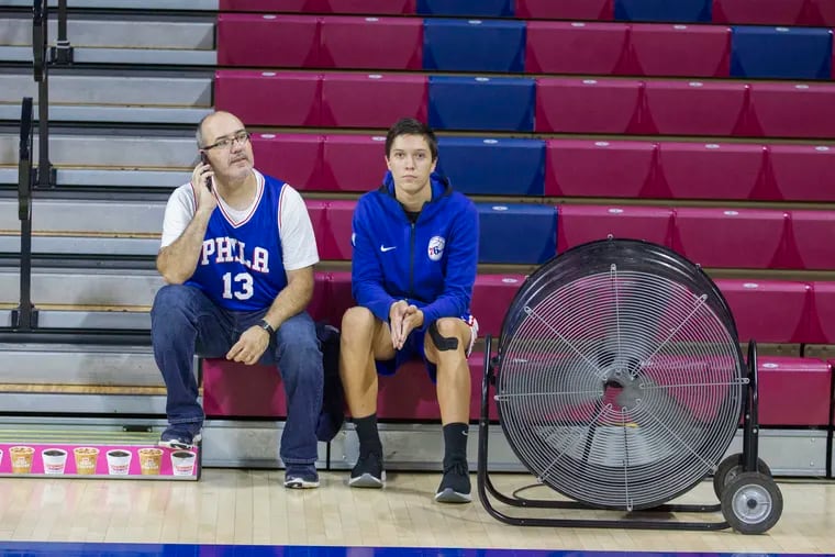 The Sixers "Blue x White Scrimmage" at the Palestra which is open to the public was cancelled due to a slippery court caused by condensation on Sept. 25, 2018.  Some early arriving fans sit by a large court side fan unit.