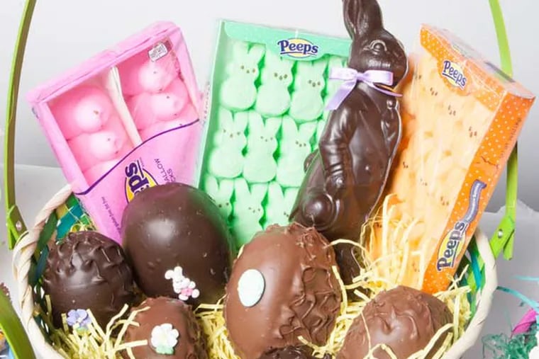 An Easter basket loaded up with chocolate eggs, Peeps, and other candies.