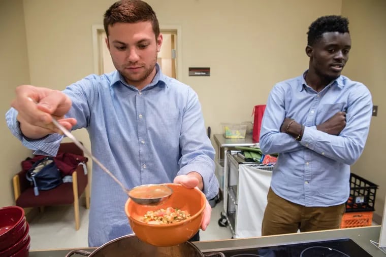Temple medical student David Pioquinto ladels out a bowl of lentil soup he and classmates made in November 2016, during a healthy cooking class at the Lewis Katz School of Medicine. Hilario Yankey awaits his share.