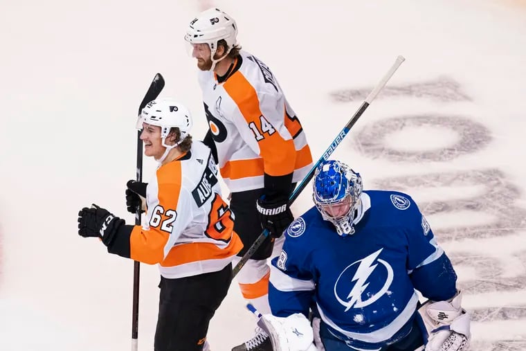 Tampa Bay Lightning goaltender Andrei Vasilevskiy (right) looks down as  Flyers right wing Nic Aube-Kubel (62) celebrates his second goal, with Sean Couturier (14), during the first period Saturday in Toronto.