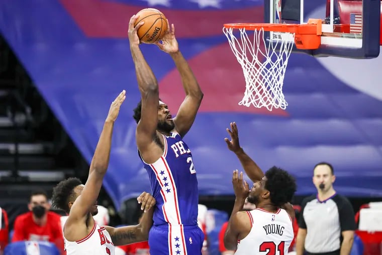 Joel Embiid (21) rises up for a shot over Chicago Bulls forward Thaddeus Yong (21) during the second quarter.