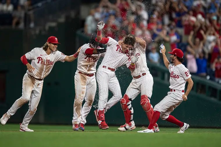 Philadelphia Phillies' Nick Maton center, celebrates with teammates after hitting a game-winning RBI-single against Cincinnati Reds pitcher Alexis Diaz during the ninth inning.