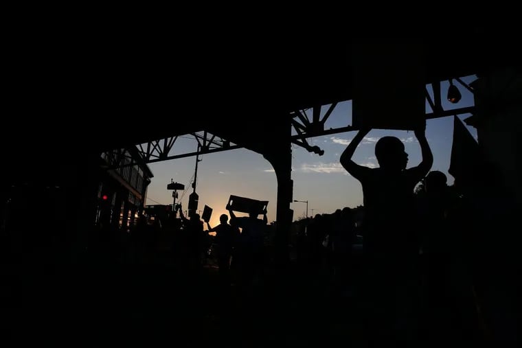 Protesters march under the El at Kensington and Allegheny Avenues during an Interfaith Peace march in Philadelphia’s Kensington section on  Aug.  19, 2017. They were protesting against gun violence and drugs. DAVID MAIALETTI / Staff Photographer