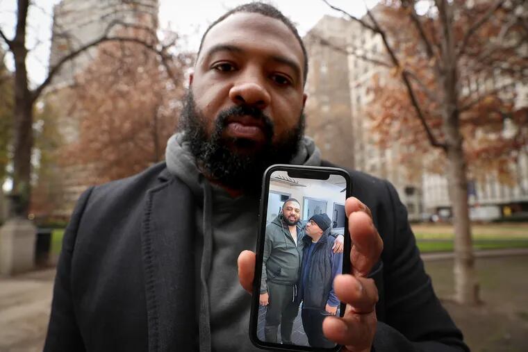 Damon Jordan displays a photo on his cellphone showing himself with his brother, Dean (at right), during a visit to Rittenhouse Square on Wednesday, Nov. 27, 2019. Dean "Dino" Jordan Jr., 51, was fatally stabbed in the park on Thursday, Nov. 21.