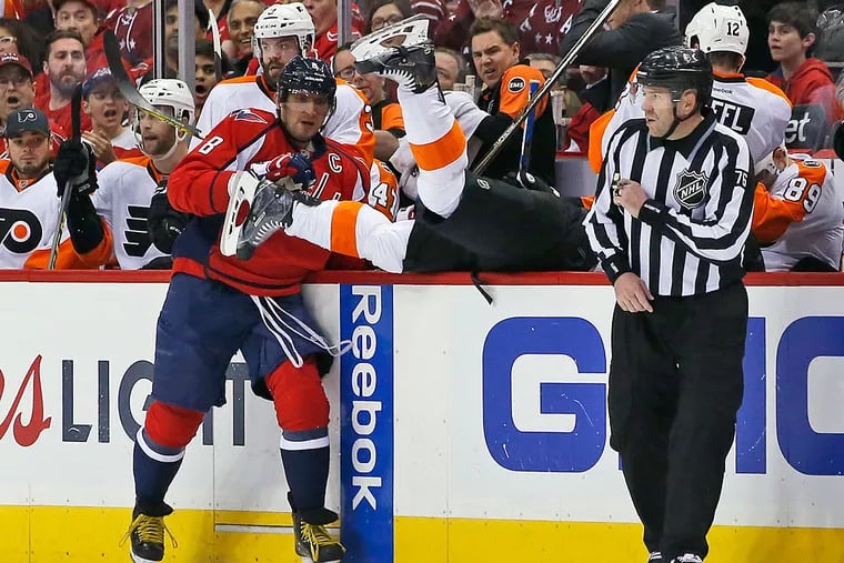 Washington Capitals left wing Alex Ovechkin (8), from Russia, checks
Philadelphia Flyers center Brayden Schenn (10) upside down into the
bench during the first period of Game 2 in the first round of the NHL
Stanley Cup hockey playoffs, Saturday, April 16, 2016, in Washington.