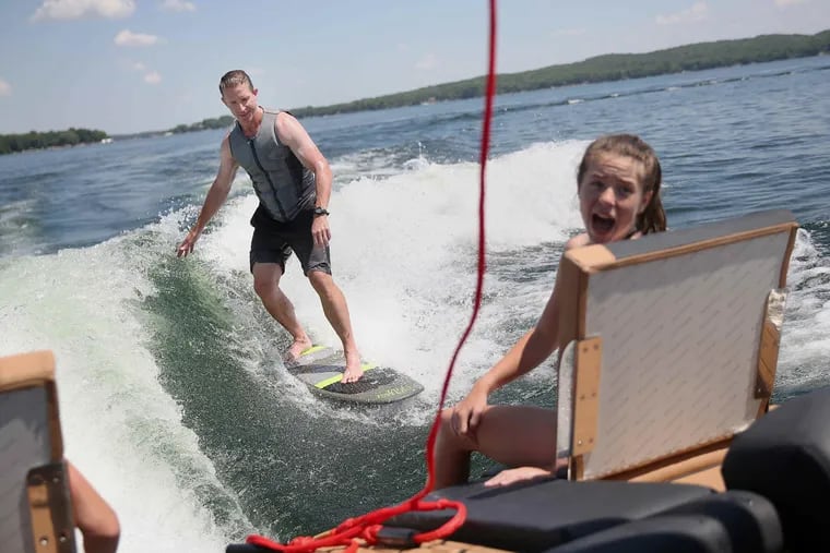 Ais daughter Avery watches from the boat as Flyers coach Dave Hakstol wake-surfed during the summer on Pelican Lake in Minnesota.The second year coach decided it was time to open up, agreeing to a series of interviews this summer at the Flyers' headquarters in Voorhees; his family's home in Grand Forks, N.D.; and his in-laws' lake house in northern Minnesota.