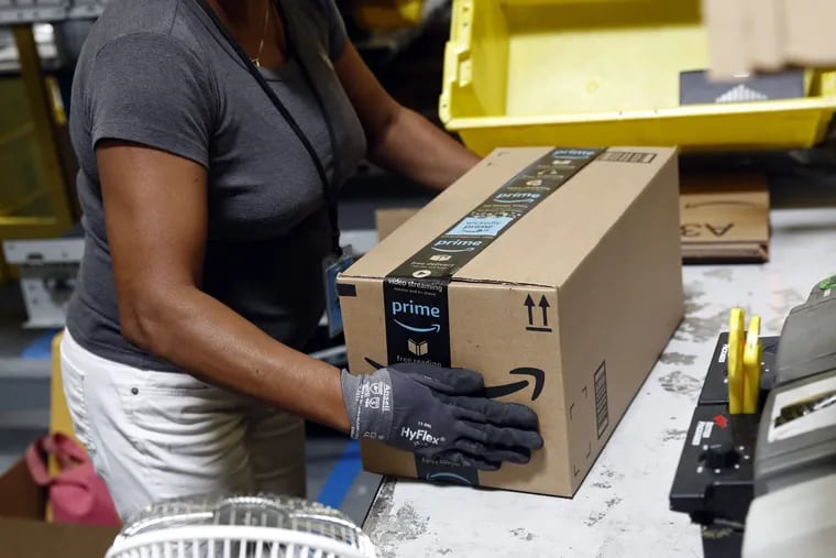 In this Aug. 3, 2017, photo, Myrtice Harris applies tape to a package before shipment at an Amazon fulfillment center in Baltimore. Amazon on Tuesday, Nov. 13, said it will split its much-anticipated second headquarters between New York and Arlington, Va. In addition, the online retailer said it will open an operations hub in Nashville, creating 5,000 jobs. (AP Photo/Patrick Semansky, File)