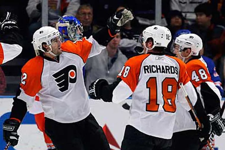 Simon Gagne, left, celebrates with Danny Briere (48) and Mike Richards (18), after scoring in the second period. (AP Photo/Julie Jacobson)