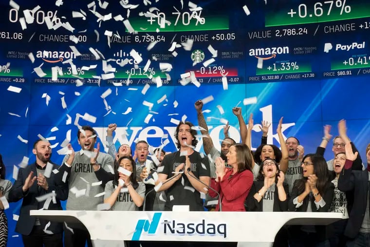In this Jan. 16, 2018 photo, Adam Neumann, center, co-founder and CEO of WeWork, attended the opening bell ceremony at Nasdaq in New York.  Office space-sharing company WeWork, which recently renamed itself The We Co., is getting ready to go public and told regulators on Aug. 14, 2019 that it has 527,000 memberships across 29 countries.  (AP Photo/Mark Lennihan, File )