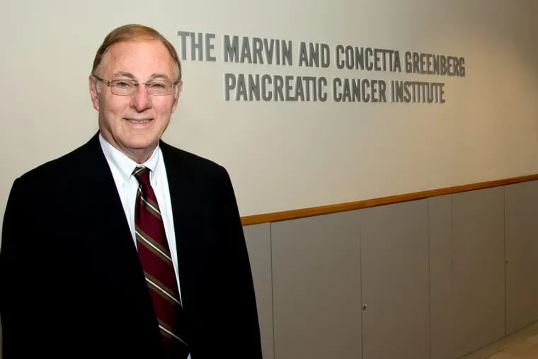 Richard I. Fisher, president and CEO of Fox Chase Cancer Center, in front of the sign for the new institute
