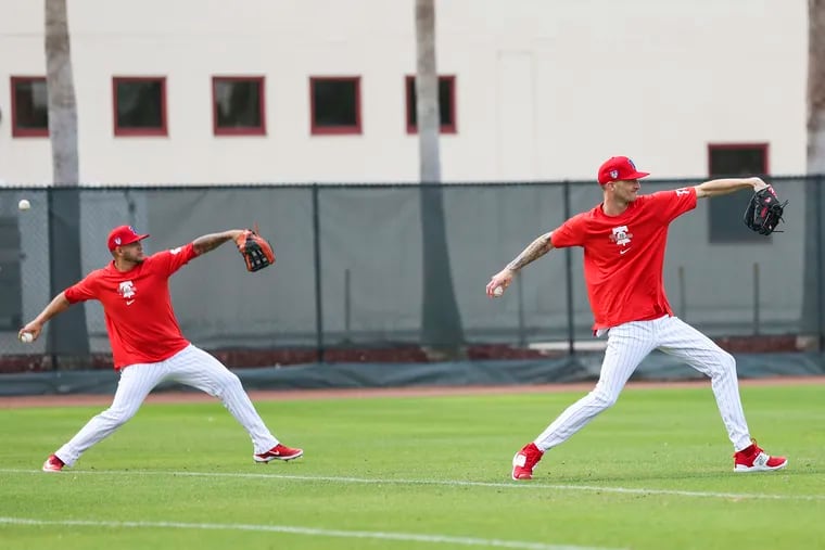 Phillies pitchers including Connor Brogdon (right) warm up.