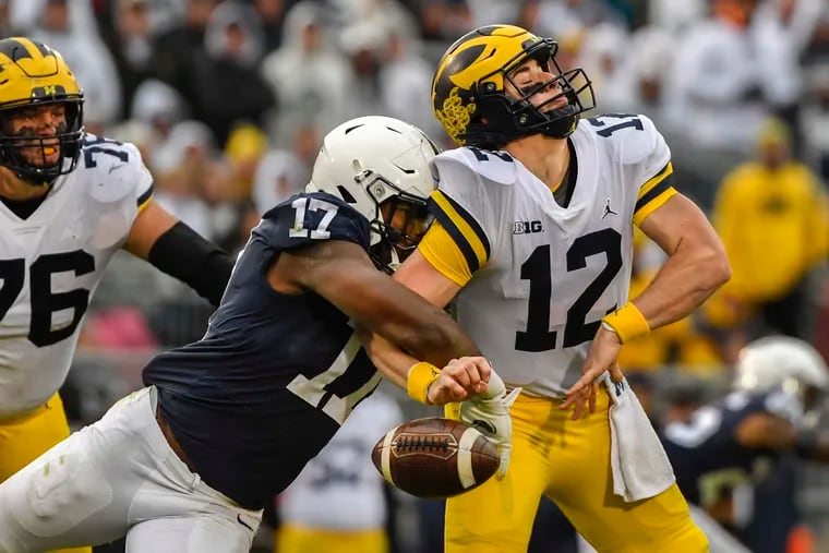 Penn State defensive end Arnold Ebiketie forces a fumble by Michigan quarterback Cade McNamara.