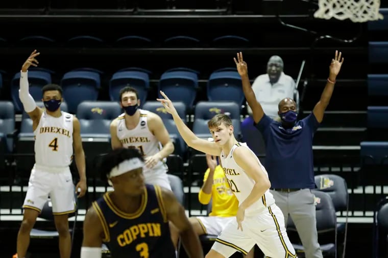 Drexel forward Mate Okros raises his arm after making a three point basket past Coppin State guard Anthony Tarke.