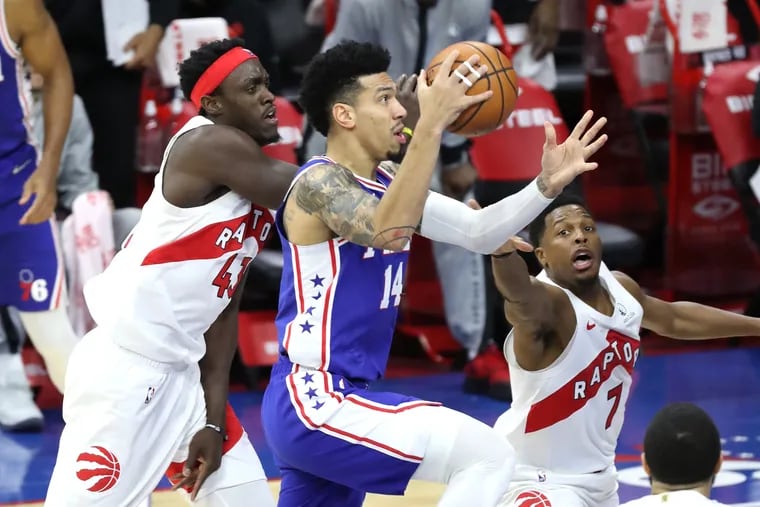 Danny Green drives between Pascal Siakam, left, and Kyle Lowry during the Sixers' 100-93 victory over the Raptors.