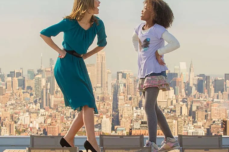 Rose Byrne (left) and Quvenzhane Wallis perform a table-top dance number at Will Stack's NYC penthouse in "Annie."