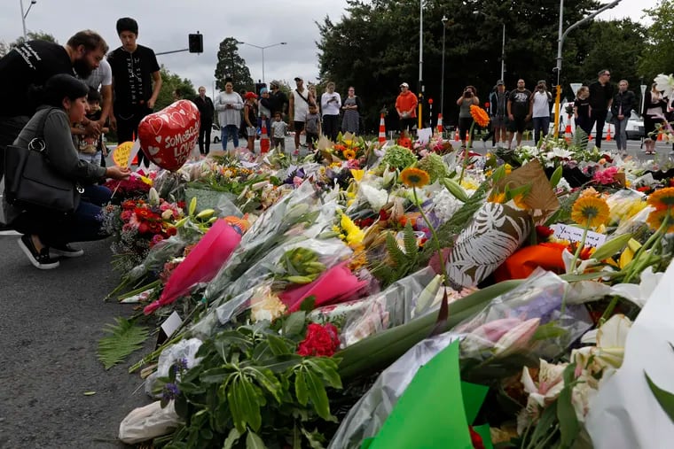 Mourners pay their respects at a makeshift memorial near the Masjid Al Noor mosque in Christchurch, New Zealand, Saturday, March 16, 2019. New Zealand's stricken residents reached out to Muslims in their neighborhoods and around the country on Saturday, in a fierce determination to show kindness to a community in pain as a 28-year-old white supremacist stood silently before a judge, accused in mass shootings at two mosques that left dozens of people dead.