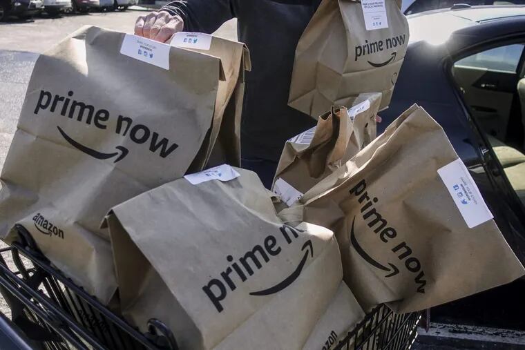 Amazon Prime Now bags full of groceries are loaded for delivery by a part-time worker outside a Whole Foods store, Thursday, Feb. 8, 2018, in Cincinnati. Amazon, which owns Whole Foods, plans to roll out two-hour delivery at the organic grocer this year to those who pay for Amazon's $99-a-year Prime membership. Amazon.com Inc. said deliveries started Thursday in Austin, Texas; Cincinnati; Dallas; and Virginia Beach, Va.