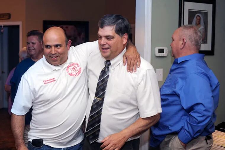 Councilman Gary Stevenson (center), a former fire chief, celebrates his Paulsboro primary win at his home with Councilman John A. Giovannitti. (TOM GRALISH / Staff Photographer)