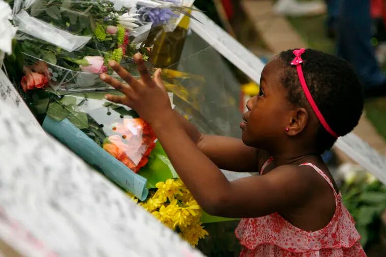 ASSOCIATED PRESS A young girl places flowers yesterday outside the home of the former South African president.