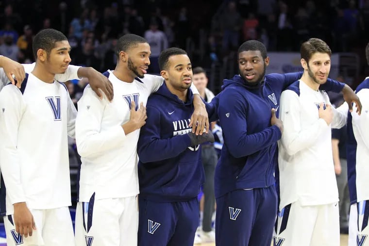 Phil Booth, left in blue, and Eric Paschall, right in blue, of Villanova stand with their teammates before their game against St. John’s at the Wells Fargo Center on Feb. 7, 2018. Both are currently out injured. Booth win a broken hand and Paschall with a concussion.