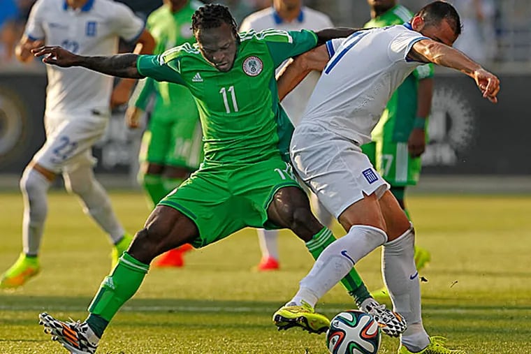 Nigeria's Victor Mikel and Greece's Loukas Vyntra battle for possession. (Ron Cortes/Staff Photographer)