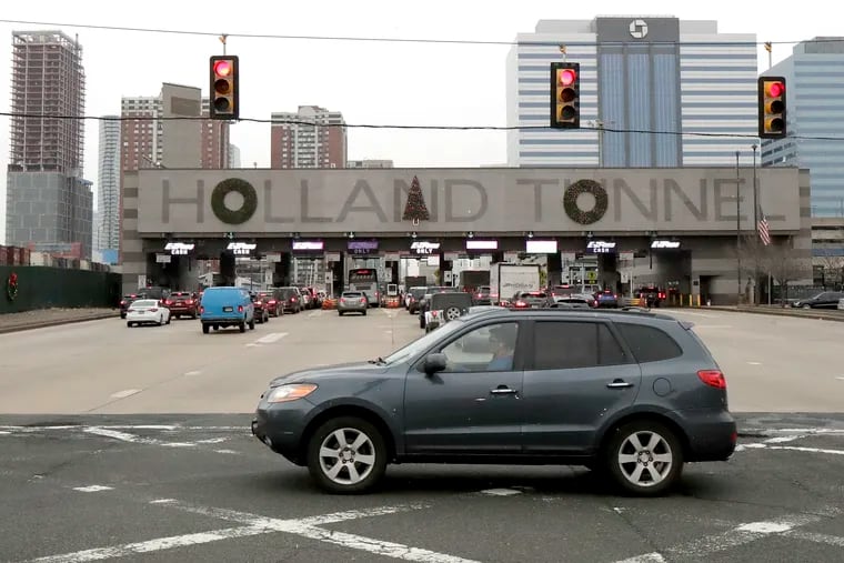 FILE - In a Thursday, Dec. 13, 2018 file photo, holiday decorations adorn the letters on the toll booth structure on the Holland Tunnel approach, in Jersey City. Motorists complained that the decorations don't look right. More than 21,000 people voted in a poll commissioned by tunnel operator the Port Authority of New York and New Jersey. Poll numbers were released Monday, Dec. 17. The consensus? Move the tree from over the “N” in “Holland” to over the “A,” and remove a wreath hanging over the “U.”