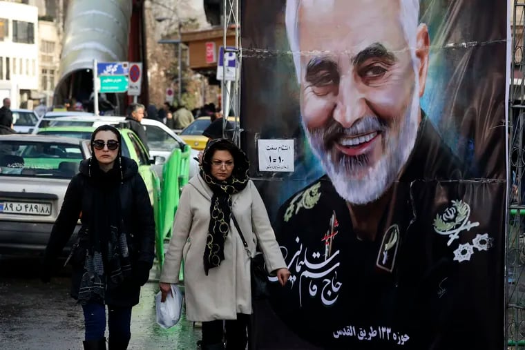 Women walk past a banner of Iranian Revolutionary Guard Gen. Qassem Soleimani, who was killed in Iraq in a U.S. drone attack on Friday, in Tajrish square in northern Tehran, Iran, Thursday, Jan. 9, 2020.