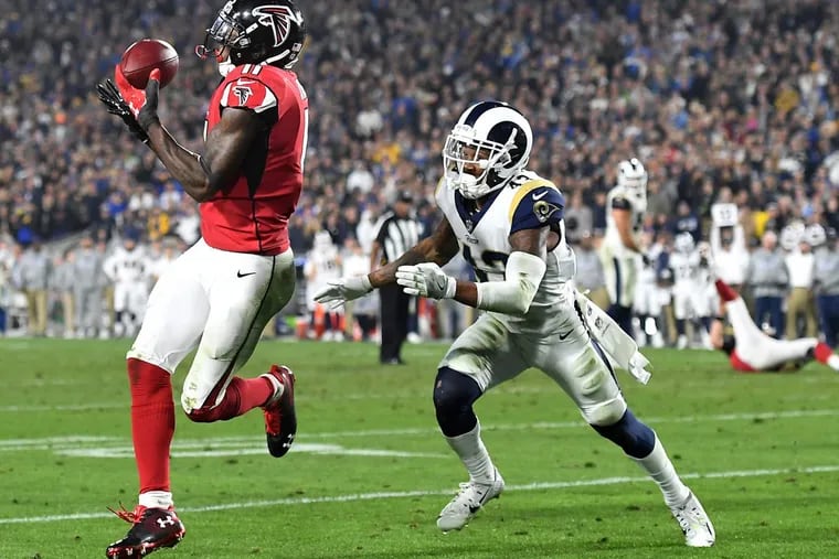 Atlanta Falcons wide receiver Julio Jones, left, catches a touchdown pass in front of Los Angeles Rams safety John Johnson in the fourth quarter of Saturday’s NFL Wild Card game. The Falcons advanced, 26-13.