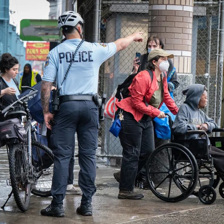 Police officers directed a person in a wheelchair who was escorted from a homeless encampment on Kensington Avenue on Wednesday. Closing encampments is a good start, but dismantling the network of drug dealers should also be a top priority, the Editorial Board writes.