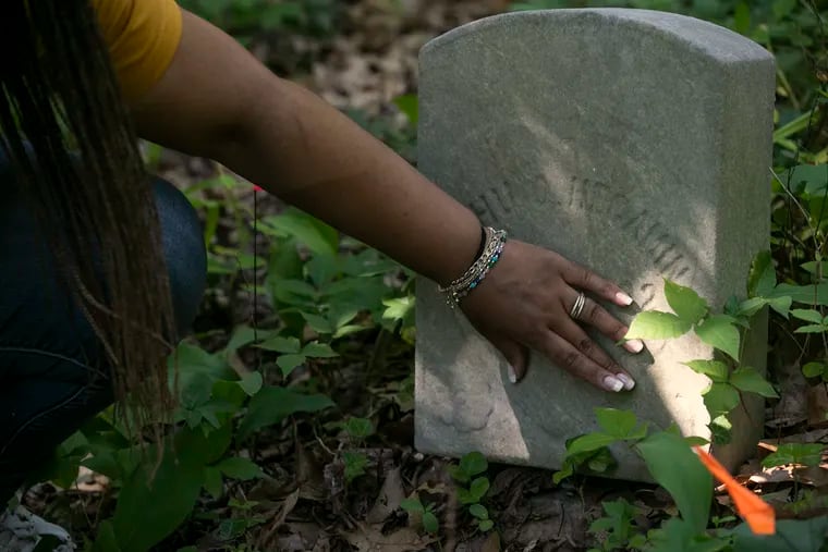 Dolly Marshall points to a grave of her ancestor inside the overgrown portion of Mount Peace Cemetery in Lawnside, NJ on Wednesday, June 30.