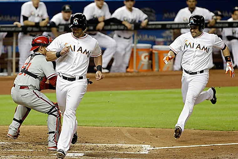 The Marlins' Justin Ruggiano and Donovan Solano score on a triple by teammate Adeiny Hechavarria in the second inning. (Alan Diaz/AP)