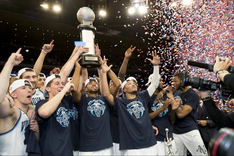 Phil Booth holds the trophy as Villanova celebrates their overtime victory over Providence in the Big East tournament championship game at Madison Square Garden on Saturday.