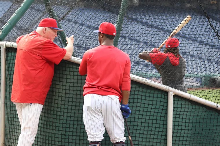 Charlie Manuel talks with Jean Segura while Roman Quinn hits during batting practice Wednesday.