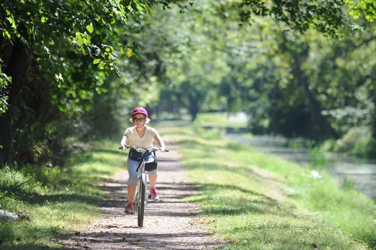 File:Woman rides her bike along the Delaware Canal in Tinicum State Park.  The state Department of Conservation and Natural Resources say proposed budget cuts could repairs to the Delaware Canal system.