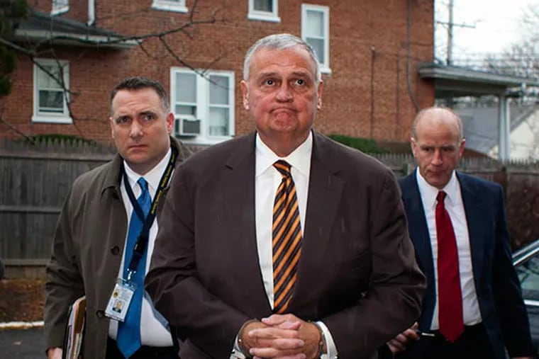Robert J. Kerns, former chairman of the Montgomery County GOP, dressed in a brown suit, stripped tie and handcuffs is escorted to his arraignment before Judge Robert Sobeck by Montco detectives Tuesday, November 26,2013. ( ED HILLE / Staff Photographer )