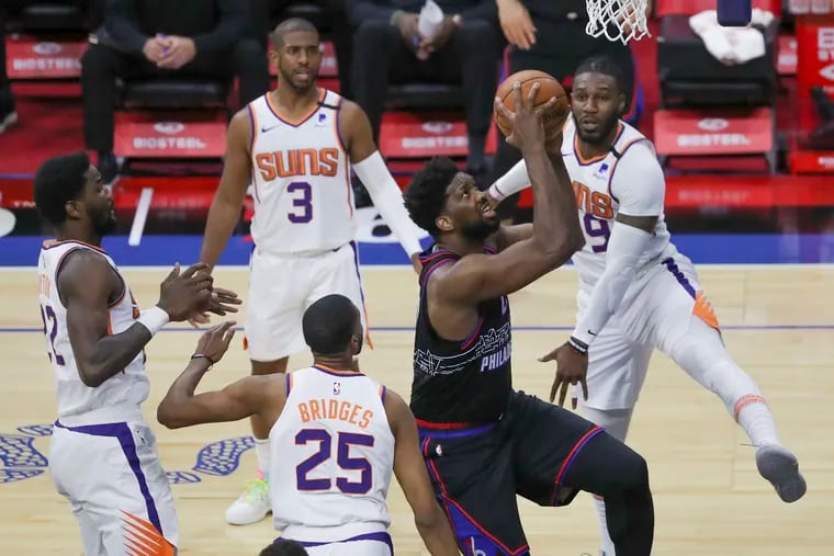 Sixers’ Joel Embiid is surrounded by Phoenix Sun defenders while going up for a shot in the first quarter Wednesday.