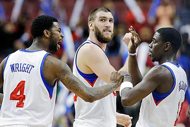The 76ers' Dorell Wright, Spencer Hawes and Jrue Holiday celebrate after a basket. (Matt Slocum/AP)