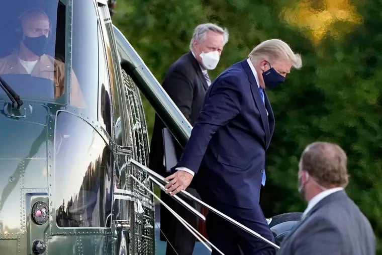 President Donald Trump arrives at Walter Reed National Military Medical Center, in Bethesda, Md., Friday, Oct. 2, 2020, on Marine One helicopter after he tested positive for COVID-19. White House chief of staff Mark Meadows is at second from left.