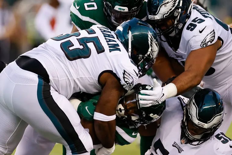 Eagles defensive end Brandon Graham, defensive tackle Marlon Tuipulotu and linebacker T.J. Edwards stop New York Jets running back Breece Hall during a preseason game on Friday, August 12, 2022 in Philadelphia.