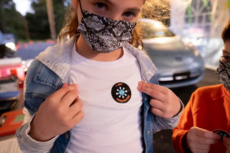 Leah Lefkove, 9, shows off her vaccination sticker just before being the first child to be vaccinated at the Viral Solutions vaccination and testing site in Decatur, Ga., on Wednesday, the first day COVID-19 vaccinations were available for children 5 to 11.
